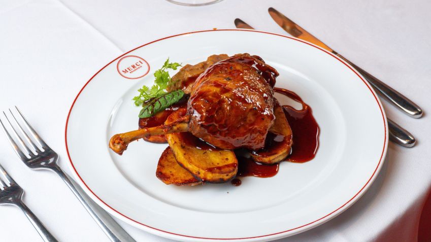 Sugestão do Merci Brasserie é um Confit de Canard preparado com coxa e sobrecoxa de pato confit, batata, cogumelos paris e molho de laranja • Lucas Alvim